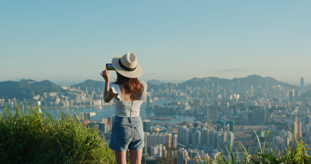 Young woman takes a picture of a city from a high vantage point